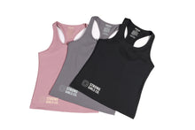 Load image into Gallery viewer, Three racer back style tops laid flat and overlapping, pink, grey and black with a logo and the words Strong Girls Co. on the bottom right side of each.
