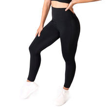 Load image into Gallery viewer, Side facing woman wearing full length black activewear leggings with pockets with a matching black crop top and white training shoes
