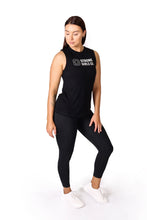 Load image into Gallery viewer, Front facing woman looking down wearing full length black activewear leggings with pockets and a black shirt with a logo on the front chest and the words Strong Girls Co.
